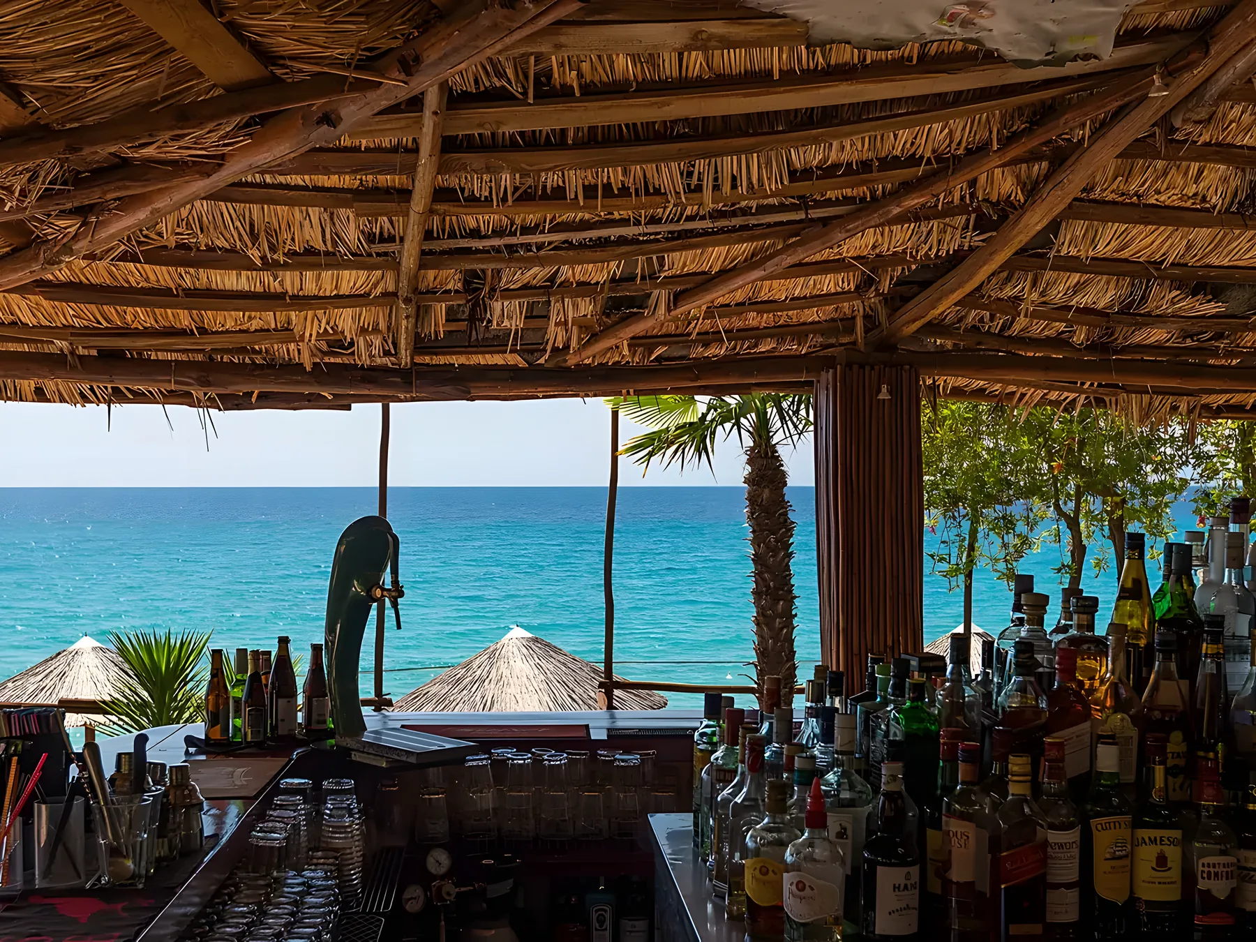 Kudu's terrace at golden hour, the low sun turning the sea and umbrellas amber
