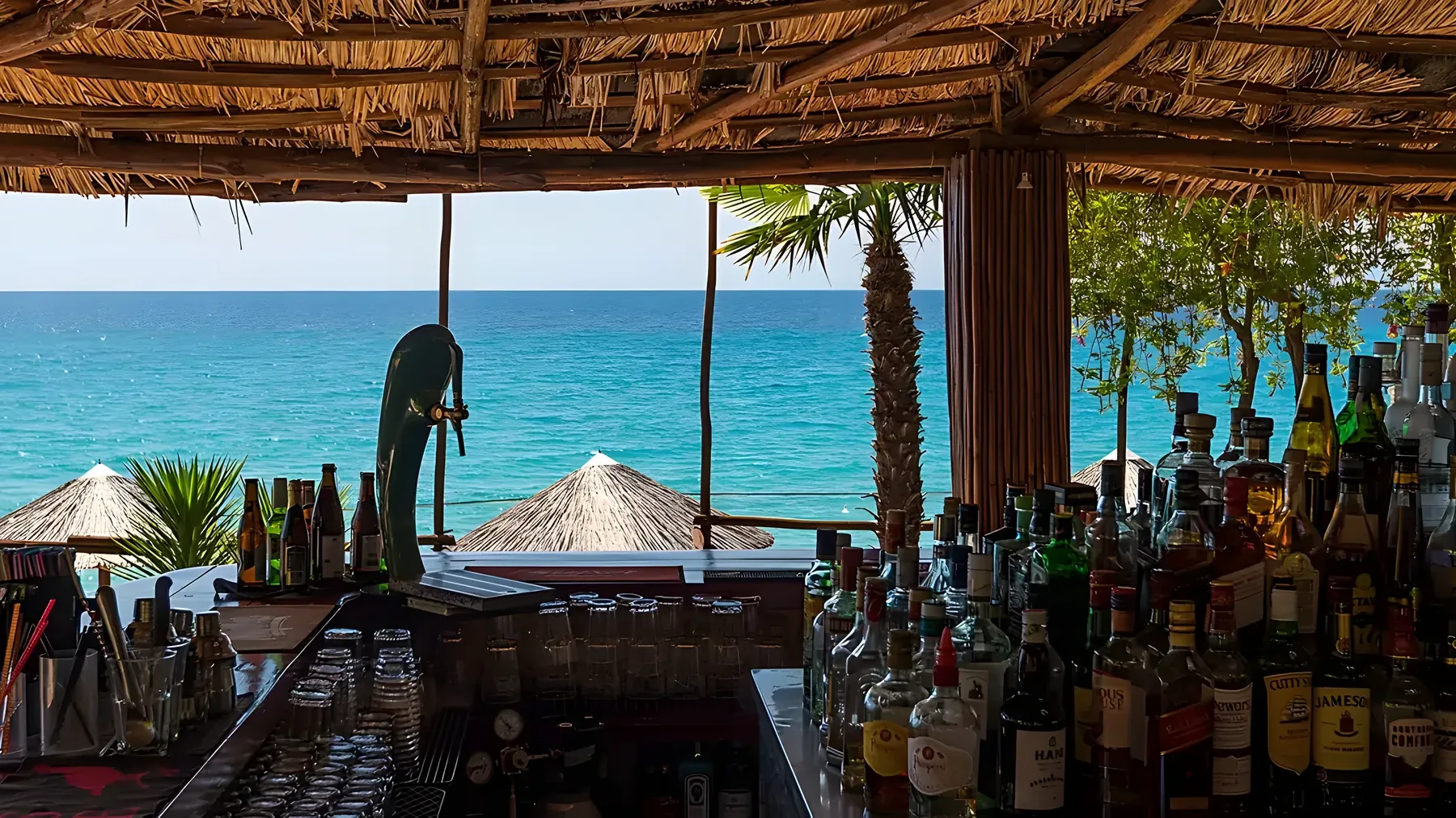 Kudu's terrace at golden hour, the low sun turning the sea and umbrellas amber
